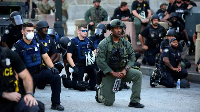 Officers kneel with protesters during a protest against the death in Minneapolis in police custody of African-American man George Floyd, in Downtown Atlanta, Georgia