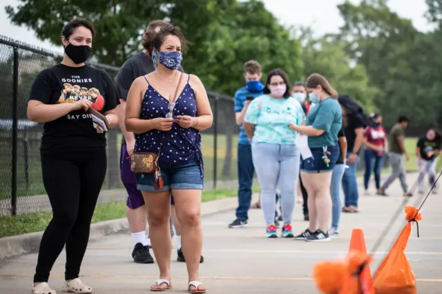 Patients wait in line at a walk up COVID-19 testing site in Dallas, Texas