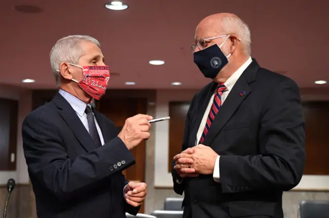 Dr Fauci (left) and CDC Director Dr Robert Redfield speak before the hearing