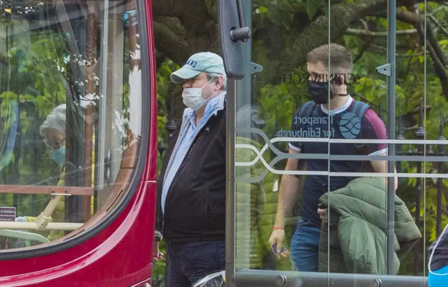 Masked passengers get on an Edinburgh bus