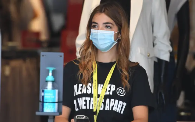 Shop staff greet customers in Edinburgh on Tuesday