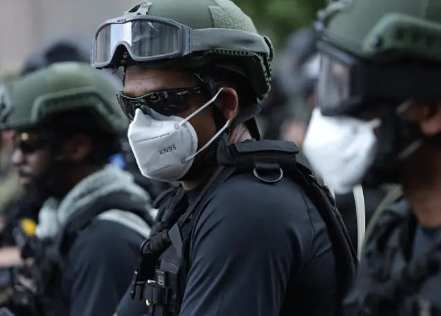 Law enforcement members hold a position as peaceful protests continue