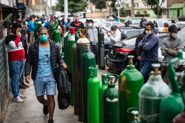 People queue to refill their empty oxygen cylinders in Callao, Peru, on June 3, 2020 amid the COVID-19 coronavirus pandemic
