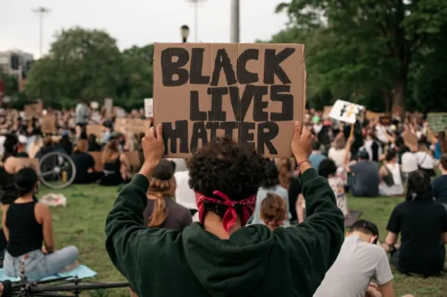 A person holds a Black Lives Matter sign