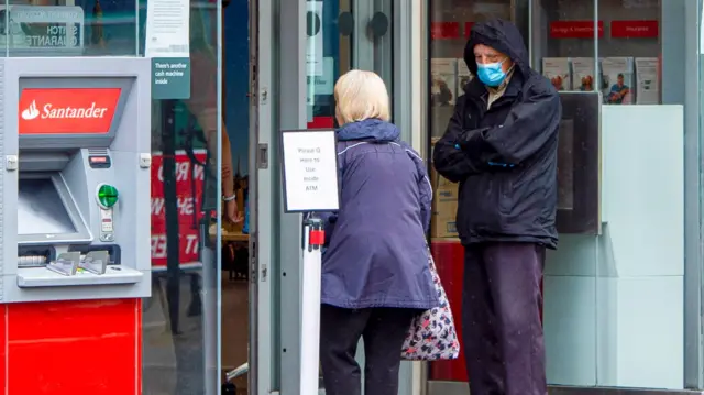 Man with face mask outside a bank