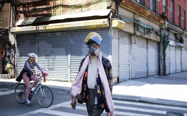 People pass by closed businesses in New York in May