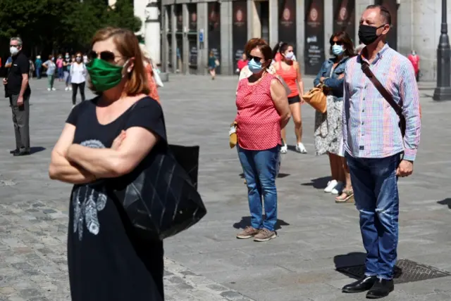 People wearing face masks observe a minute's silence in Madrid