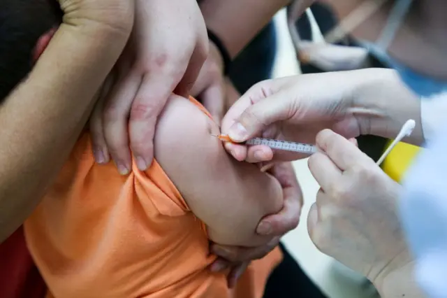 A child has a shot of vaccine at a community health center in Zhengzhou city