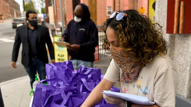 A community worker wears a fabric face mask