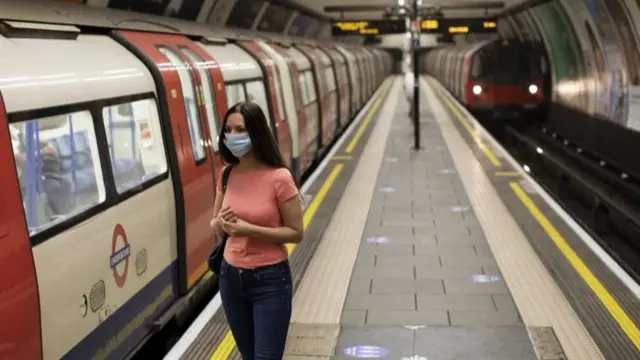 A woman wears a face covering on public transport