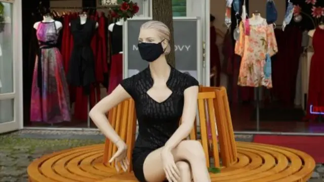 A fashion store mannequin that is wearing a face mask sits outside a clothing shop during the coronavirus crisis on June 05, 2020 in Berlin, Germany.