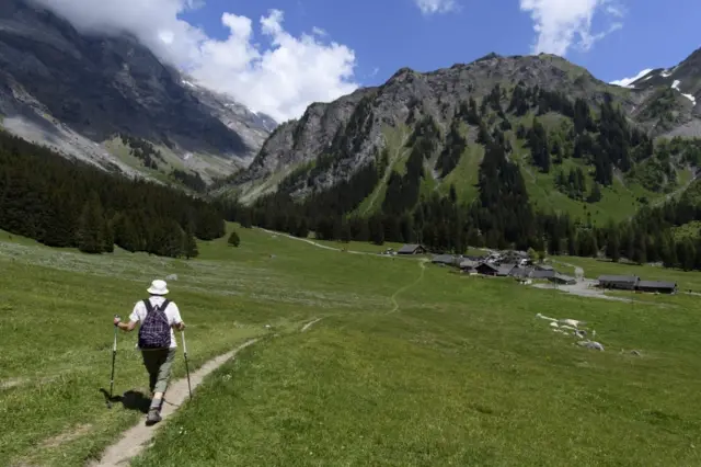 A woman hikes during a sunny day in Solalex, Switzerland