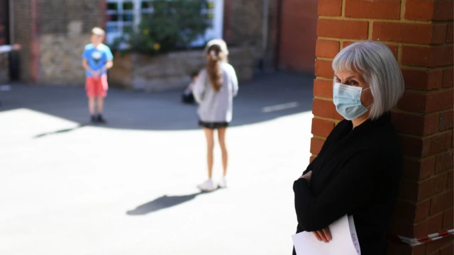 Teacher wears mask in school playground