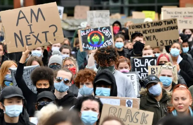 Protesters hold placards as they attend a demonstration in Manchester