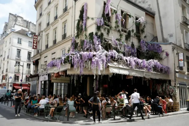 People enjoy the terrace of the restaurant Maison Sauvage in Paris