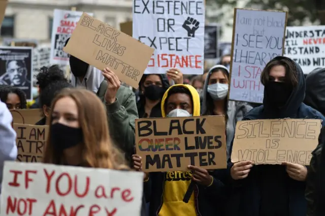 Protesters hold placcards in central London