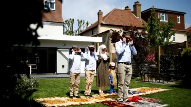 Muslim family offer Eid al-Fitr prayers at home to mark the end of the month of Ramadan