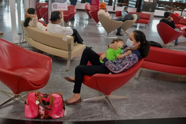 A passenger holds her baby at the departure terminal of Bangalore International Airport, India, on 2 June 2020