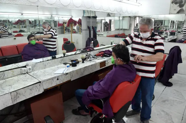 A man gets his haircut in a barbershop