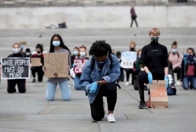 People wearing face masks and gloves take part in a kneeling protest for Black Lives Matter in London