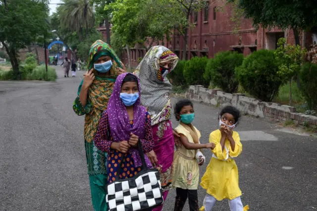 A Catholic family wearing facemasks arrives to attend Sunday prayers at the Mary Immaculate Church in Lahore on June 7, 2020.