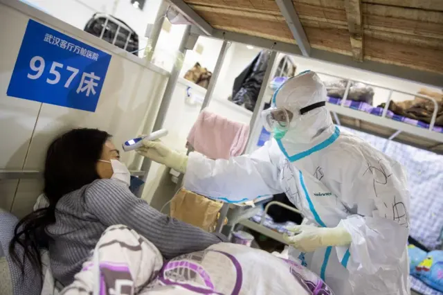 A patient's temperature is checked in a Wuhan hospital