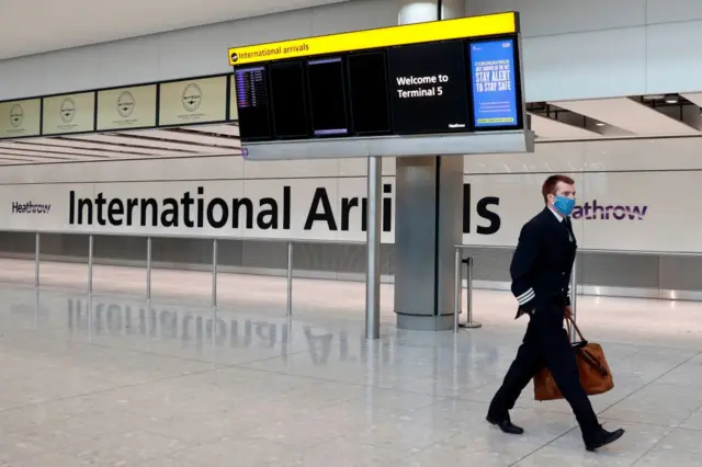 A pilot walks through Heathrow Airport