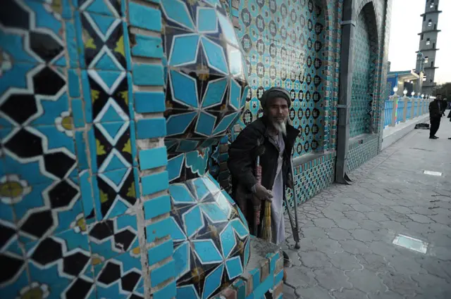 A beggar stands at a tiled entrance of the ancient blue mosque in Mazar-e-Sharif. November 10, 2015