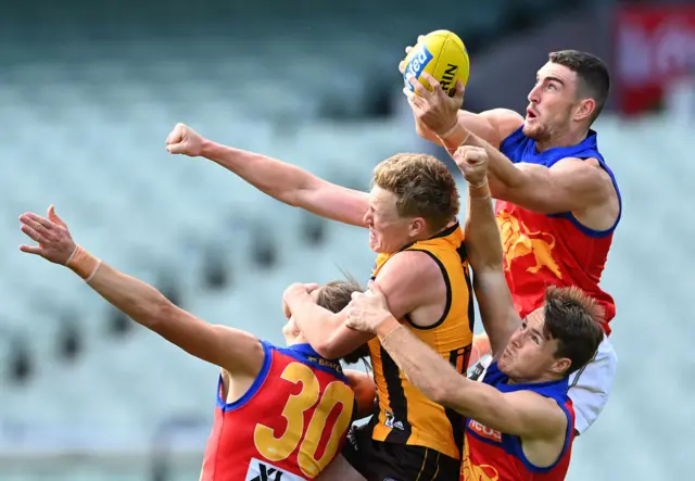 Brisbane and Hawthorn players contest for a mark at an AFL game in March