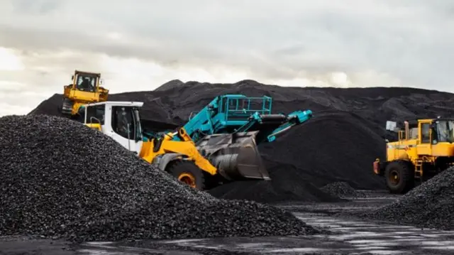 Coal being moved by heavy diggers