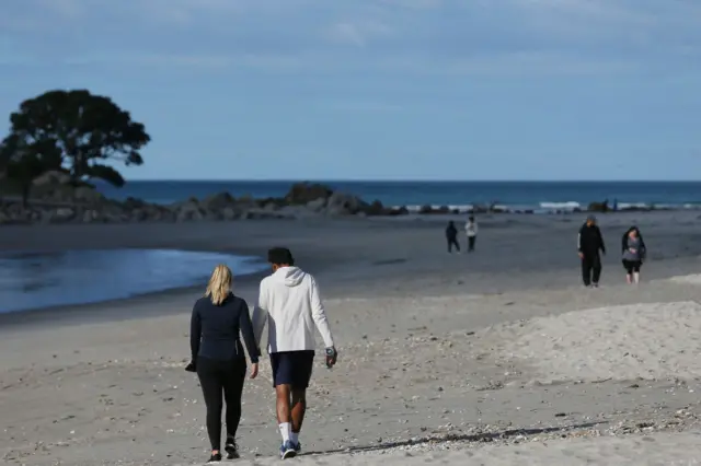 People walking on a beach in New Zealand