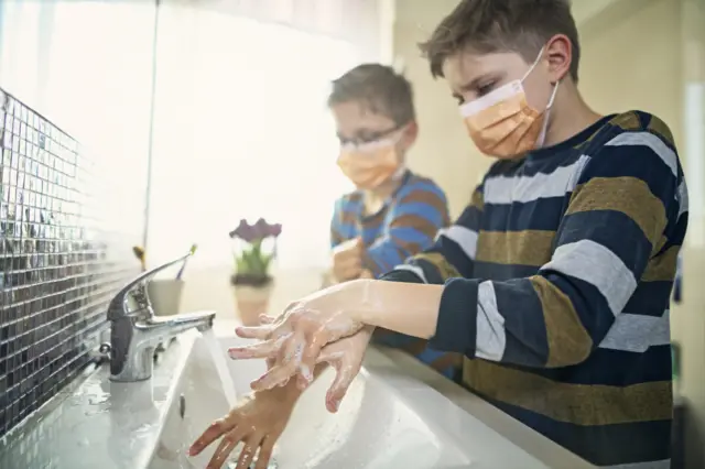 Two boys washing their hands