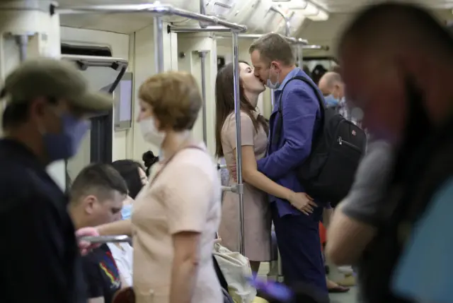 People kiss on the Moscow underground