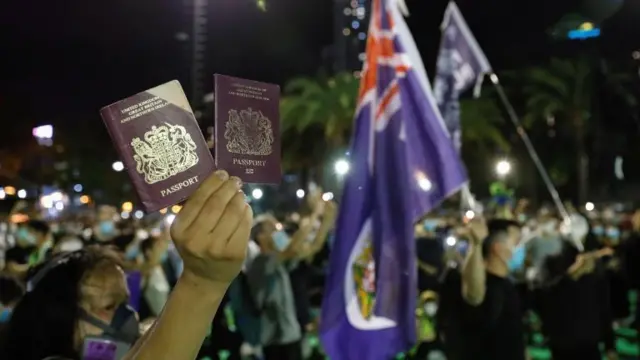 A pro-democracy demonstrator raises their British National Overseas (BNO) passports during a protest against new national security legislation in Hong Kong, China June 1, 2020