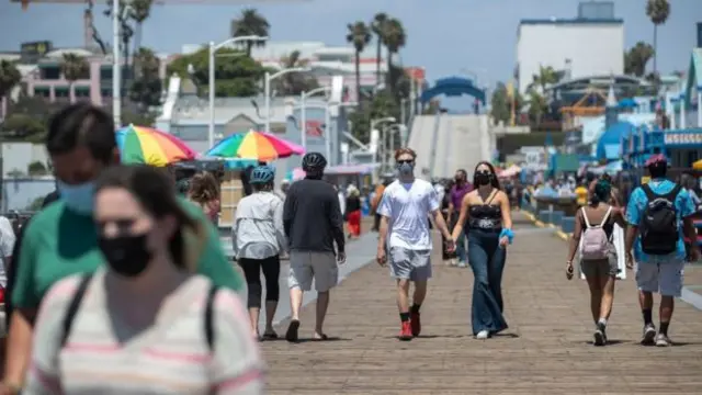 People walk along a beach front