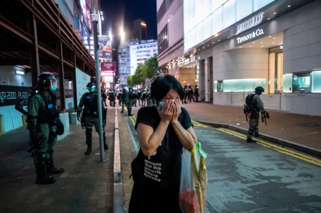 Woman covers her face during protests