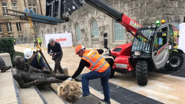 The statue being put back