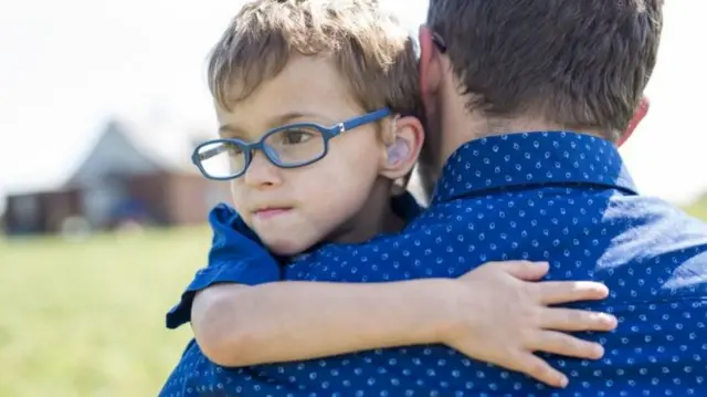 A boy hugging his dad