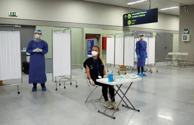 Staff await arrivals at an airport in Greece