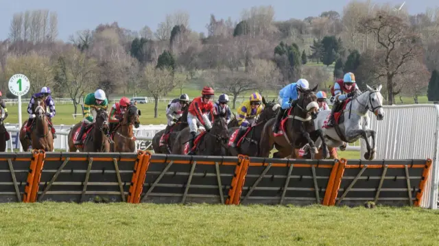 Horses jumping a fence at Uttoxeter