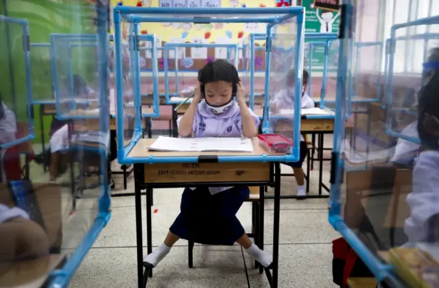 A Thai student sits in a socially distanced classroom