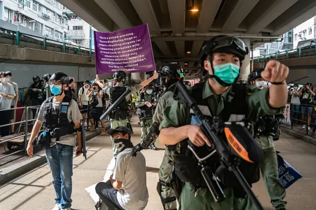 Riot police detain a man as they raise a warning flag during a demonstration