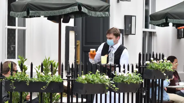 Waiter wearing face covering