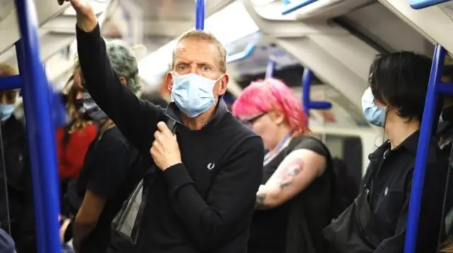 A man wearing a face mask on the Tube
