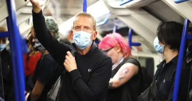 A man on the Tube wearing a face mask