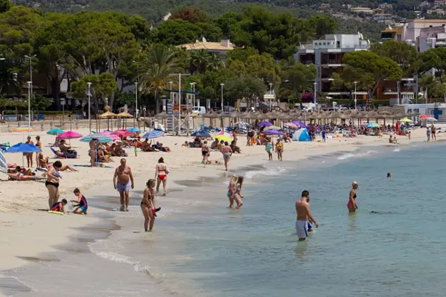 People enjoy a day out at Es Carregador Beach in Calvia on the Spanish island of Majorca