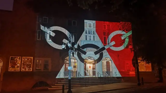 Town hall lit up with flag