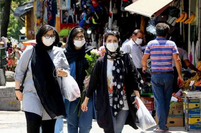 Iranian women wearing protective gear amid the Covid-19 pandemic, shop at the Tajrish Bazaar market in the capital Tehran