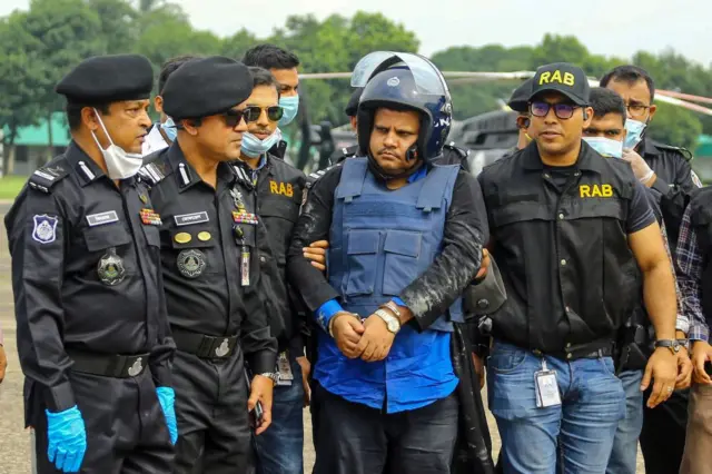 Rapid Action Battalion (RAB) personnel escort Regent hospital Chairman Mohammad Shahed (C)