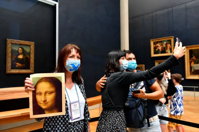 Visitors to the re-opened Louvre museum in Paris wear face coverings